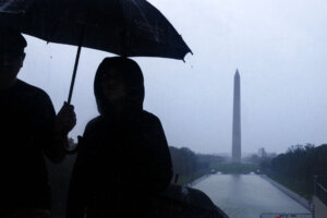 Tourists are seen on the National Mall during heavy rain
