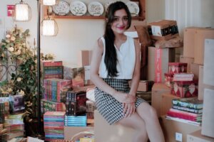 Emily Bhatnagar sits among books for donation