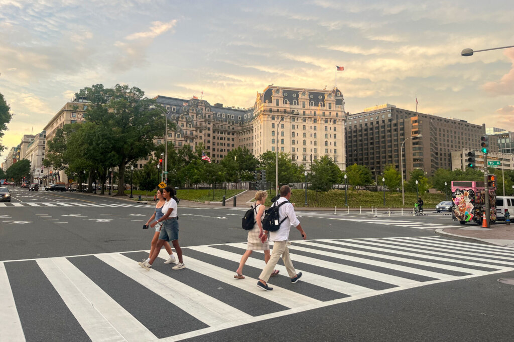 A group of people cross a busy street, Washington, DC. USA