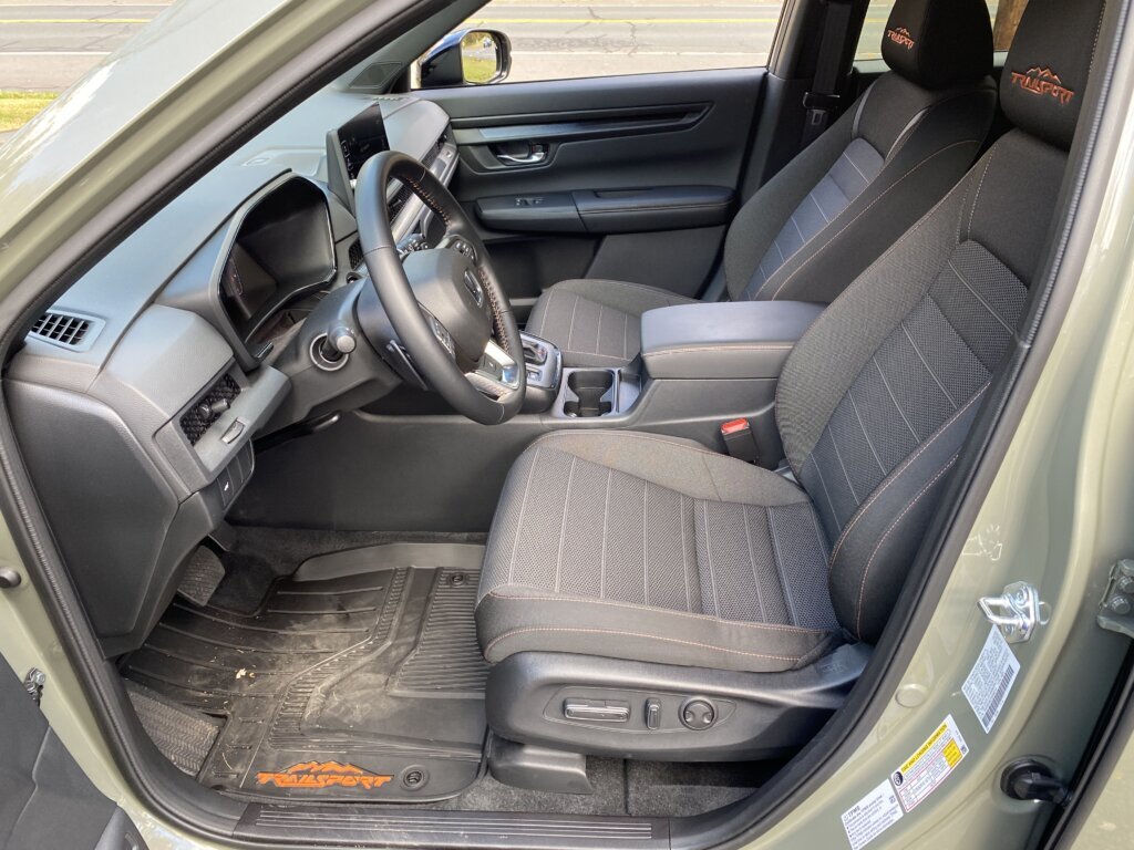Inside, the TrailSport Hybrid keeps things simple. It has a straightforward interior, featuring black cloth seats with orange stitching and the TrailSport logo embroidered on the headrests.