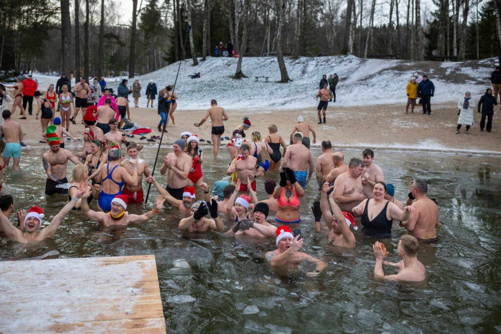Swimmers get into the icy water during the traditional New Year's Dive in a lake near Vilnius, Lithuania, Thursday, Jan. 1, 2026. (AP Photo/Mindaugas Kulbis)