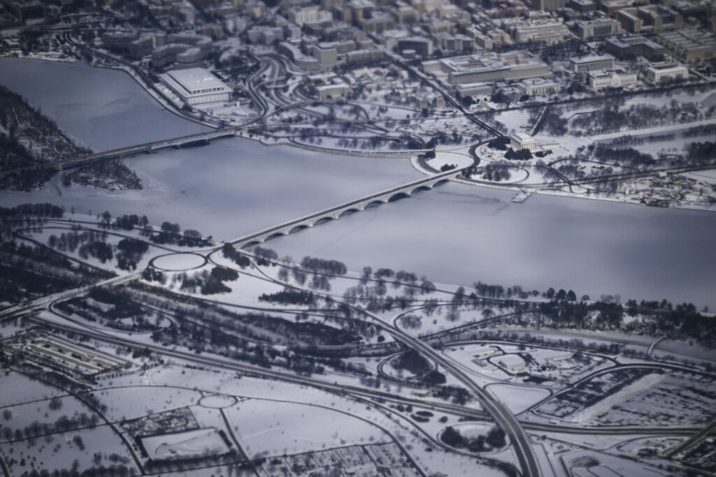 This aerial view shows a snow-covered Washington, DC, including the Lincoln Monument, the Kennedy Center, the Potomac River and the National Mall from Air Force One on January 27, 2026. President Trump is on his way to Clive, Iowa to deliver a speech on the economy and energy. (Photo by Brendan SMIALOWSKI / AFP via Getty Images)