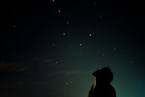Man looking up at night sky watching stars