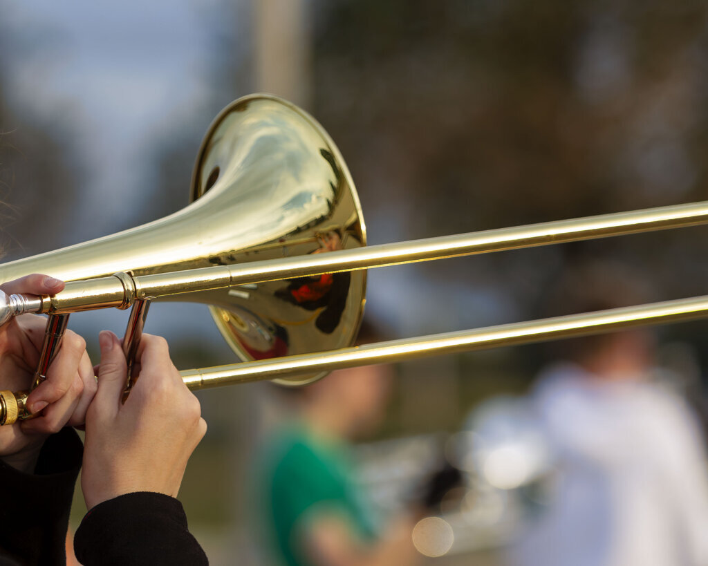 Hands of a musician playing a trombone at rehearsal