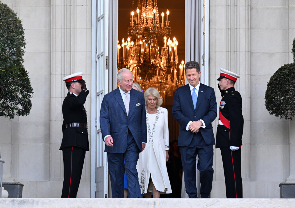 Britain's King Charles III and Queen Camilla arrive at a garden party at the British Embassy with Britain's Ambassador to the U.S, Christian Turner and his wife Claire Turner, left, Monday, April 27, 2026, in Washington. (Roberto Schmidt/Pool via AP)