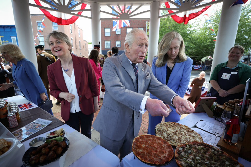 Britains King Charles III, accompanied by Virginia Gov. Abigail Spanberger, right, speaks with employees of Melting Pot Pizza during a parade and block party, Thursday, April 30, 2026, in Front Royal, Virginia. (Win McNamee/Pool Photo via AP)