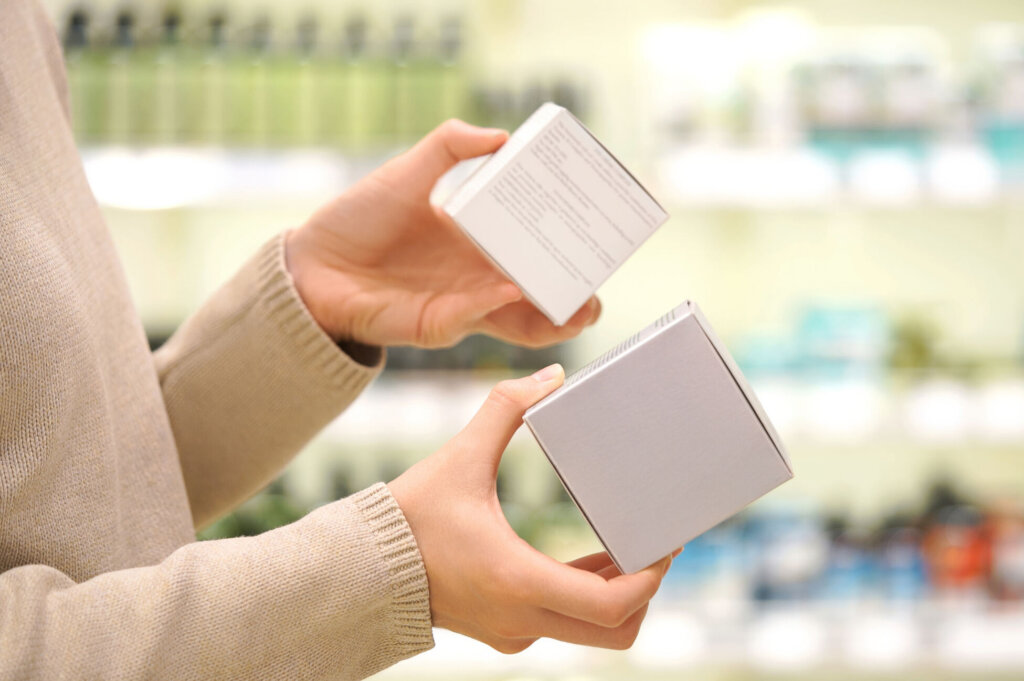 Shopper reading ingredient labels, comparing and choosing a cosmetic product